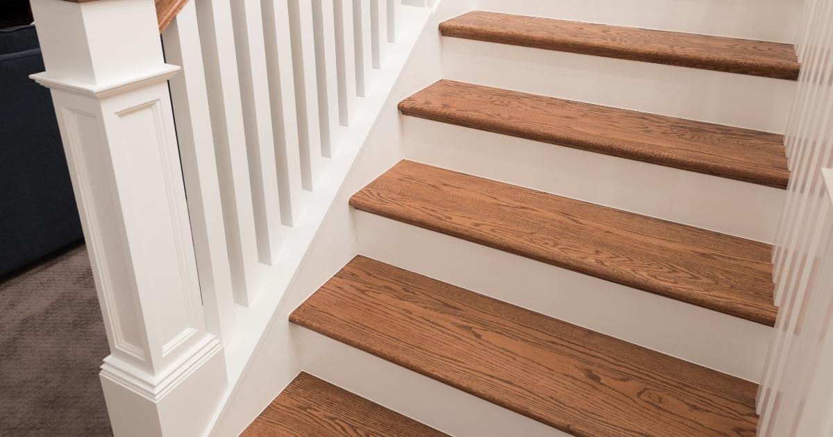 Escalier en bois poncé avec contre marche et balustrade peintes en blanc.