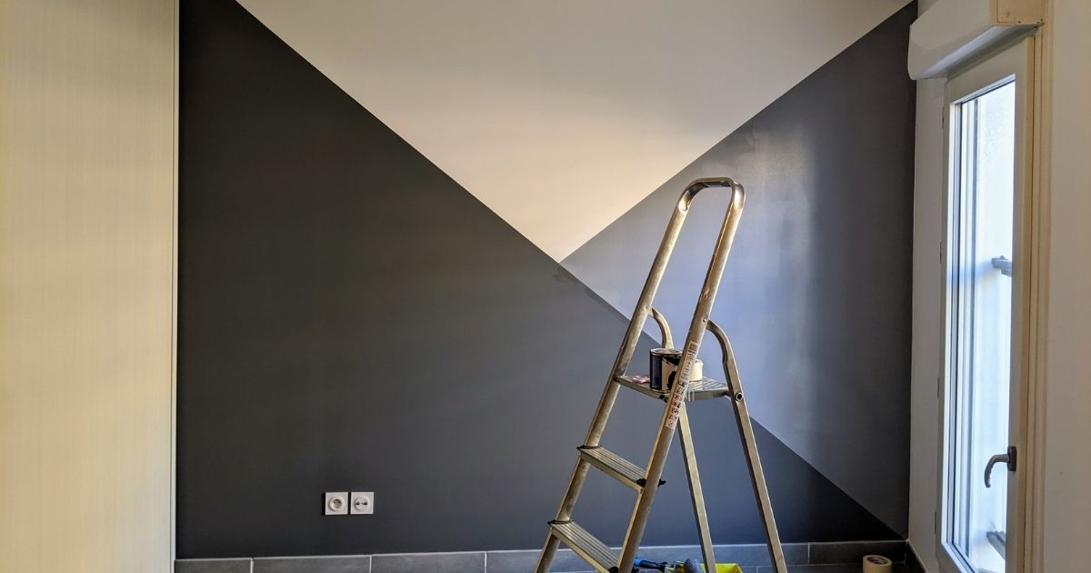 Mur peint en trois couleur avec une échelle et un pot de peinture dans une chambre à coucher.
