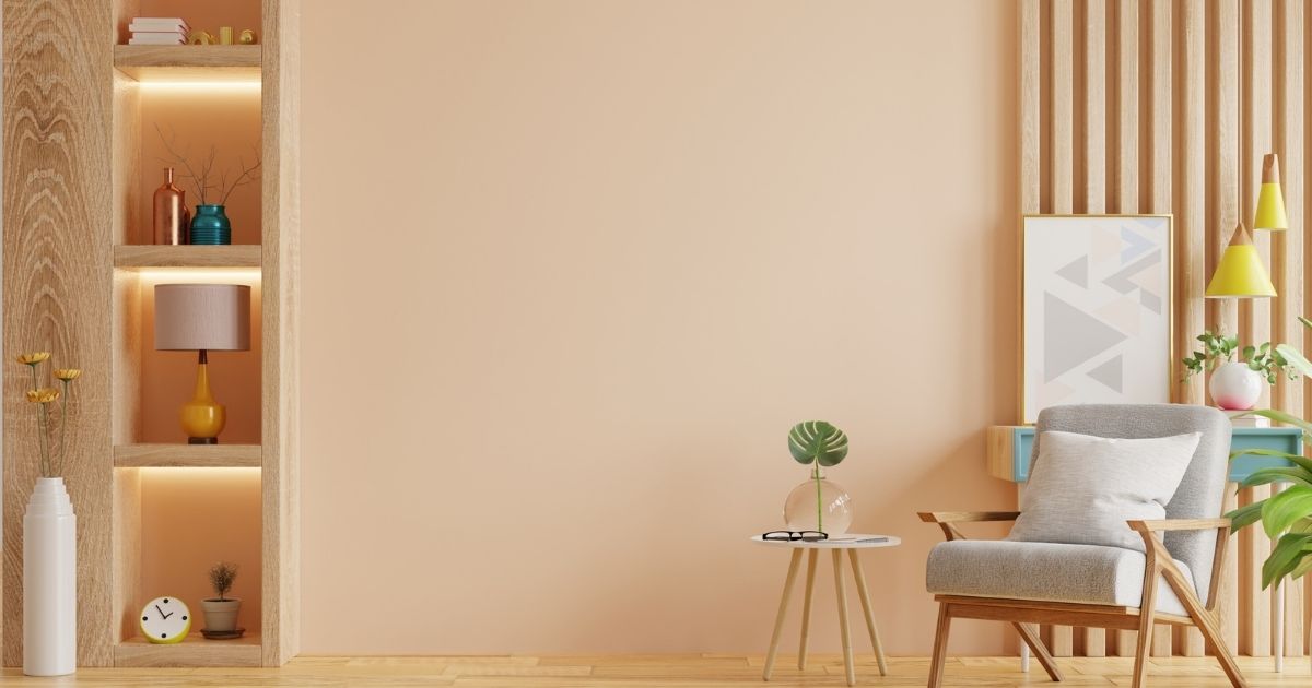 Salon couleur peche / prune avec fauteuil et bibliothèque en bois.